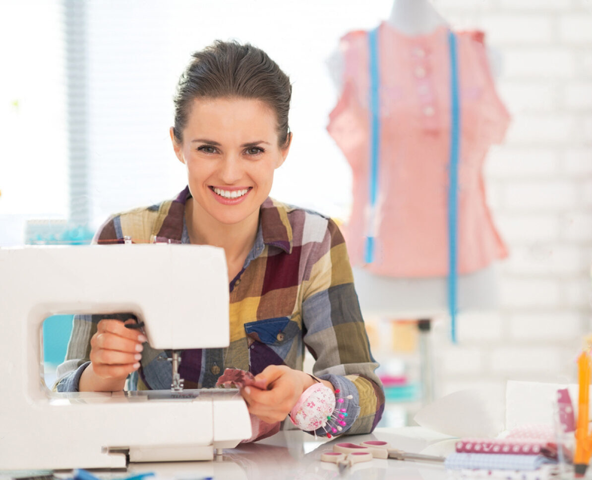 stock-photo-happy-seamstress-sewing-in-studio-194889401